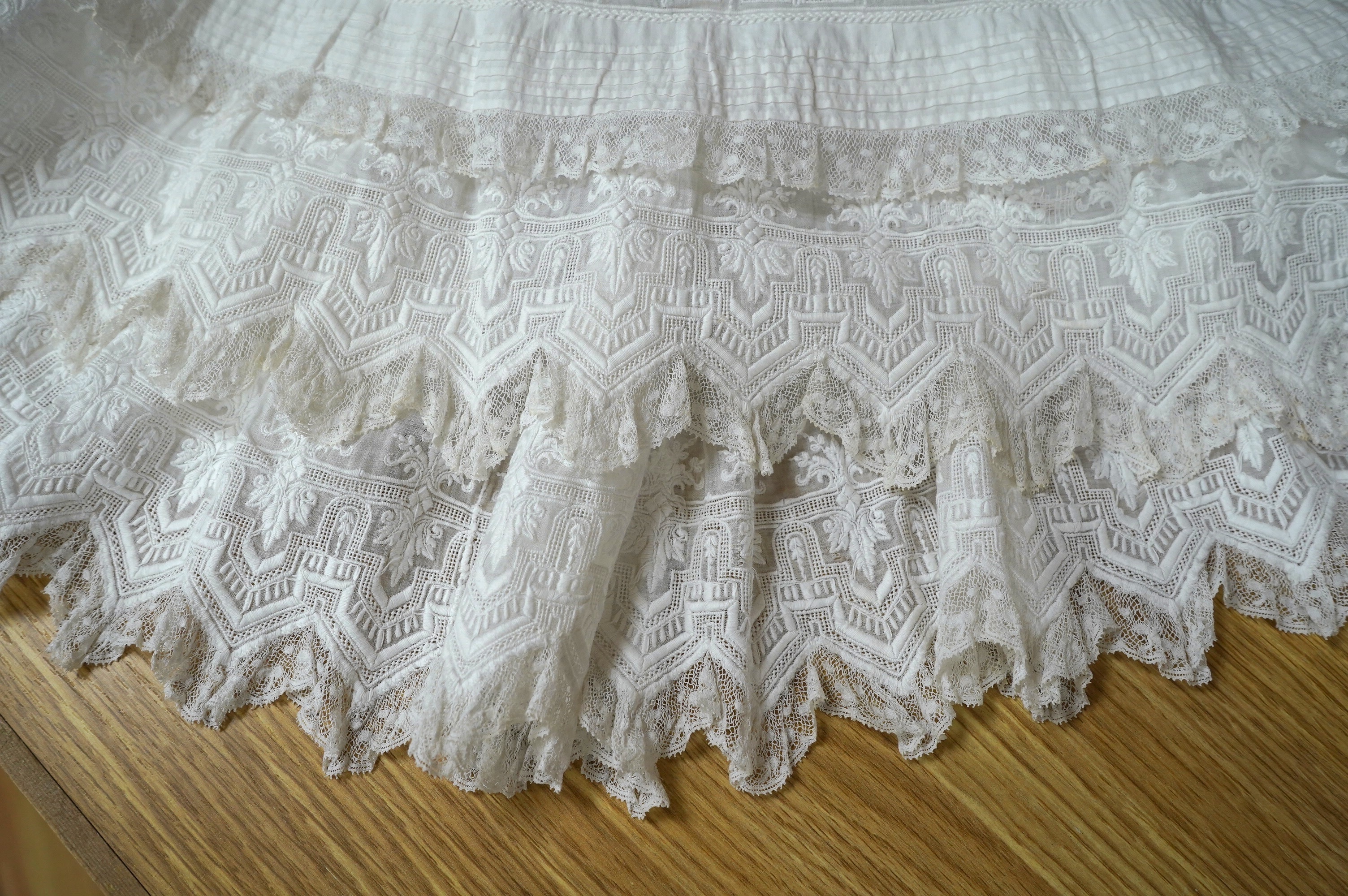 Two unusual 19th century intricately white worked children’s dresses, one hand worked with fine panels of white work, feather stitching and tucking, edged and inserted with hand made Valenciennes lace, the other worked i